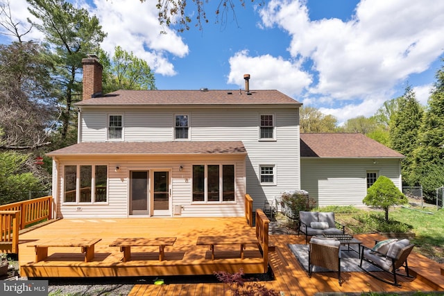 rear view of property with a wooden deck, an outdoor hangout area, a chimney, and roof with shingles