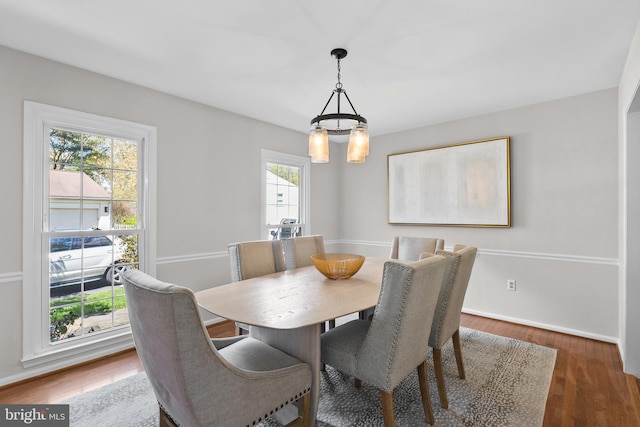 dining space with baseboards and wood finished floors