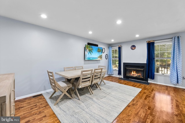dining room with visible vents, baseboards, wood finished floors, and recessed lighting