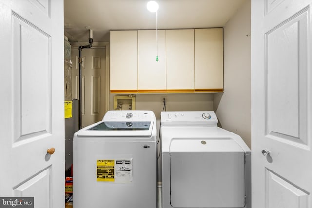 washroom featuring cabinet space and washing machine and clothes dryer