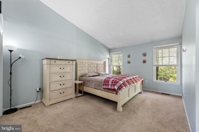 bedroom with vaulted ceiling, visible vents, baseboards, and light carpet