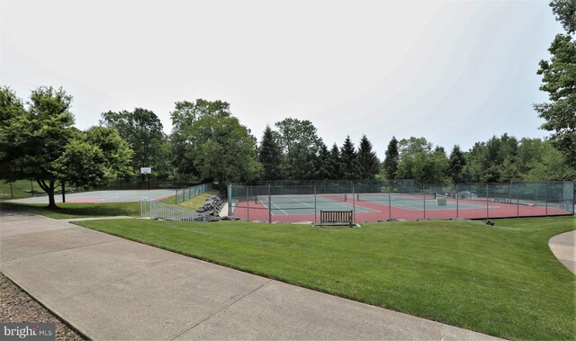 view of sport court featuring fence and a lawn
