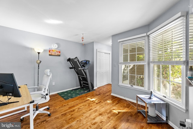 office area with plenty of natural light, wood finished floors, and baseboards
