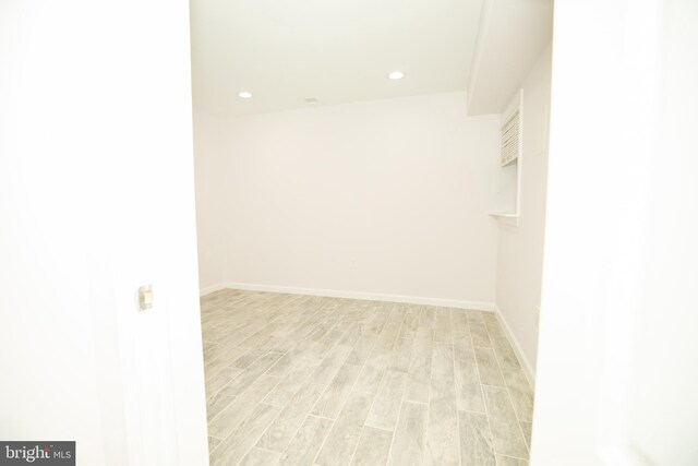 spare room with recessed lighting, light wood finished floors, and baseboards