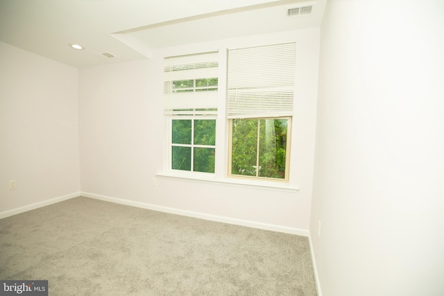 carpeted empty room with visible vents, baseboards, and recessed lighting