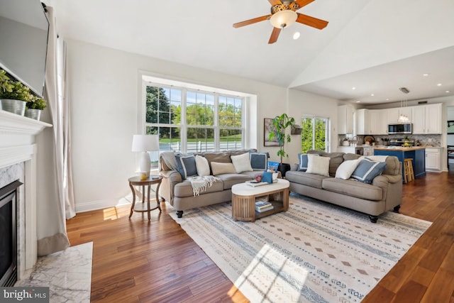 living room featuring recessed lighting, a premium fireplace, wood finished floors, ceiling fan, and high vaulted ceiling