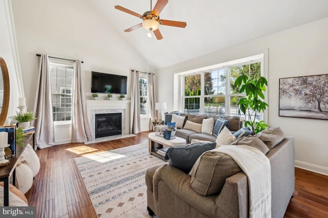living room with high vaulted ceiling, a wealth of natural light, a ceiling fan, and wood finished floors