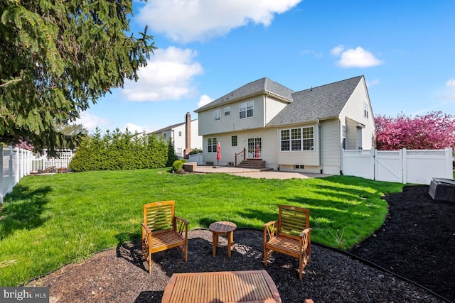 rear view of house with a fenced backyard, a gate, a patio, entry steps, and a lawn