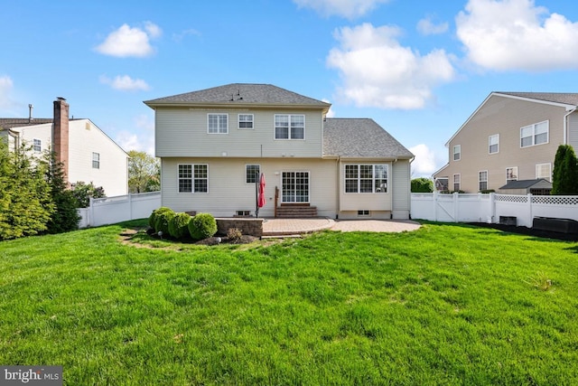 back of property with a lawn, a patio area, entry steps, and a fenced backyard