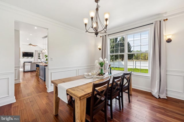 dining area featuring ornamental molding, wood-type flooring, a decorative wall, and a healthy amount of sunlight