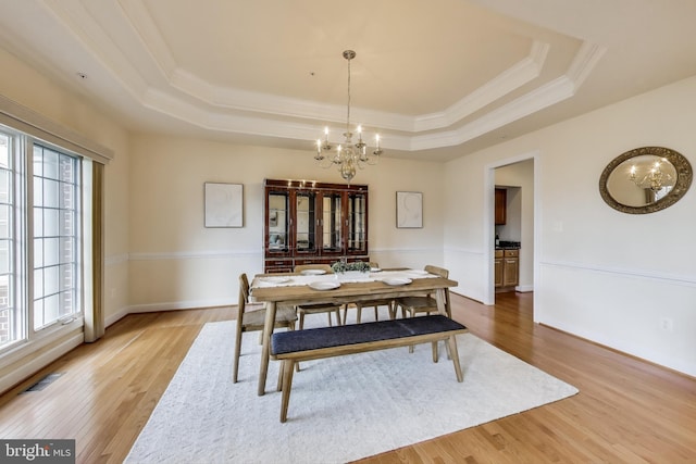 dining room featuring visible vents, a tray ceiling, a chandelier, and a healthy amount of sunlight