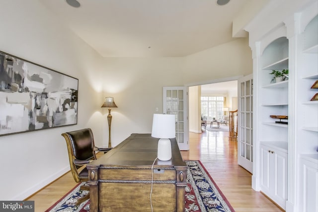 home office with light wood-style floors and french doors