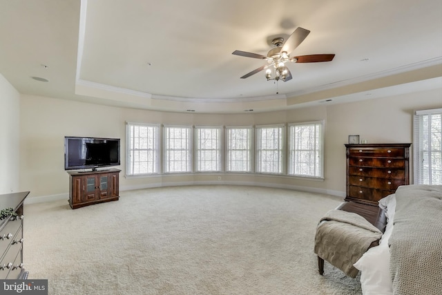 living area featuring a wealth of natural light, ornamental molding, and a raised ceiling