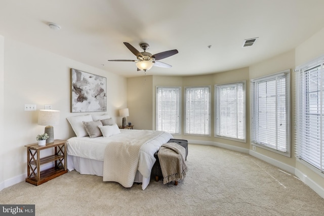 carpeted bedroom with ceiling fan, baseboards, and visible vents