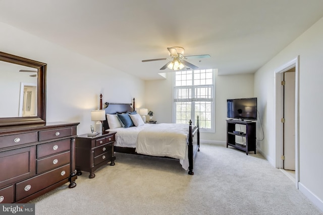 bedroom with ceiling fan, baseboards, and light carpet