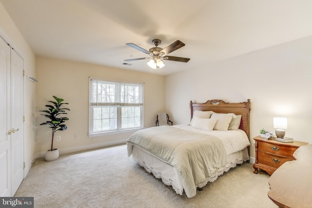 bedroom featuring baseboards, visible vents, light colored carpet, and ceiling fan
