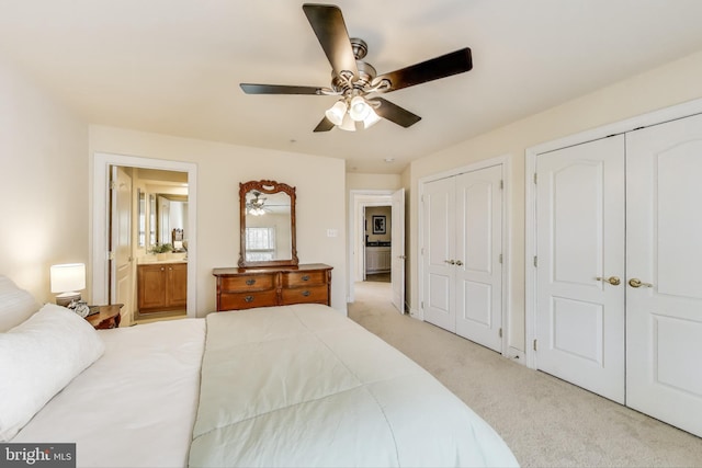 bedroom with multiple closets, carpet flooring, a ceiling fan, and connected bathroom