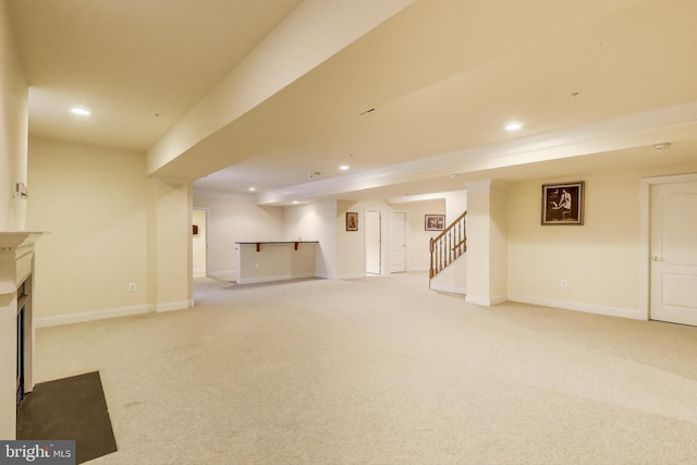 finished basement featuring light carpet, recessed lighting, and stairway