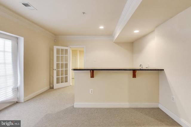 empty room featuring light carpet, ornamental molding, and visible vents