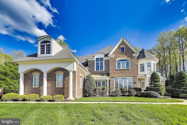view of front of home featuring brick siding and a front yard