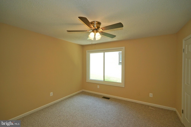 unfurnished room with visible vents, a textured ceiling, carpet, and ceiling fan