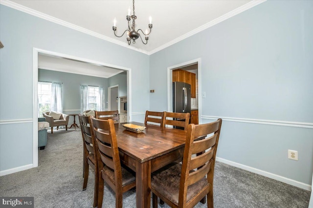 carpeted dining space with an inviting chandelier, baseboards, and ornamental molding
