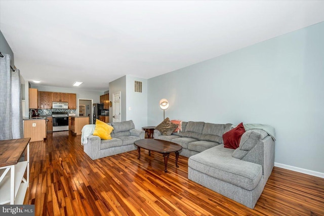 living area with baseboards, dark wood finished floors, and visible vents