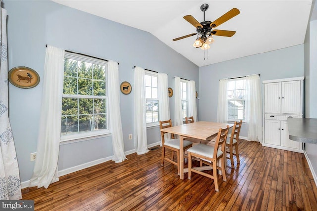 dining space featuring dark wood-style flooring, baseboards, a ceiling fan, and lofted ceiling
