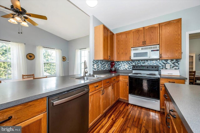 kitchen featuring electric range oven, a sink, white microwave, stainless steel dishwasher, and lofted ceiling
