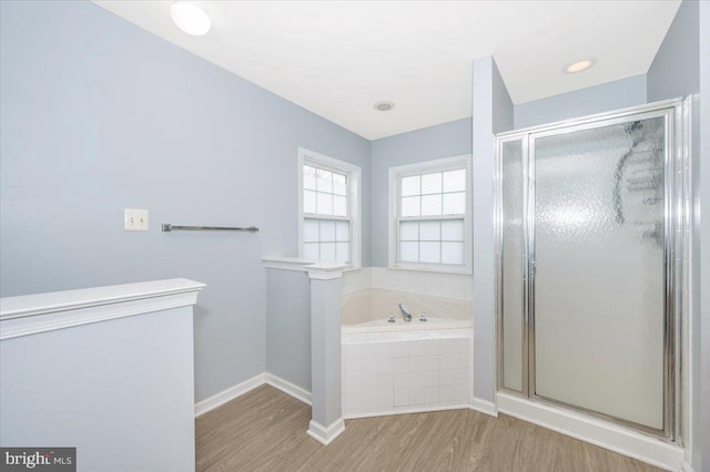 full bath with a bath, baseboards, a stall shower, and wood finished floors