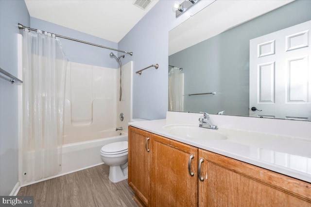 bathroom with vanity, shower / tub combo with curtain, toilet, visible vents, and wood finished floors