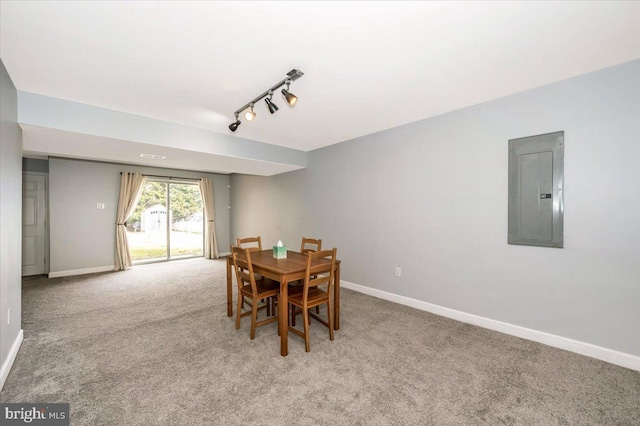 dining room featuring carpet flooring, baseboards, rail lighting, and electric panel