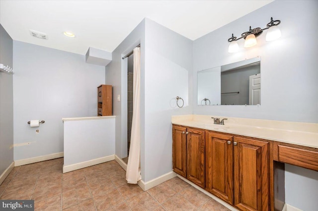 full bath with a shower with shower curtain, vanity, baseboards, and visible vents