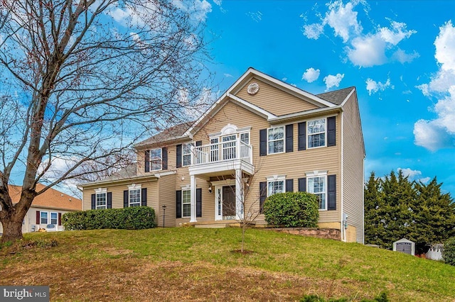 colonial-style house with a front lawn and a balcony