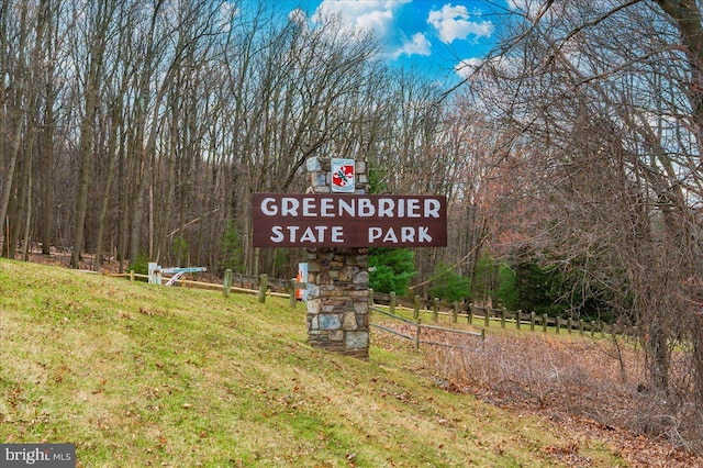 community / neighborhood sign with a wooded view