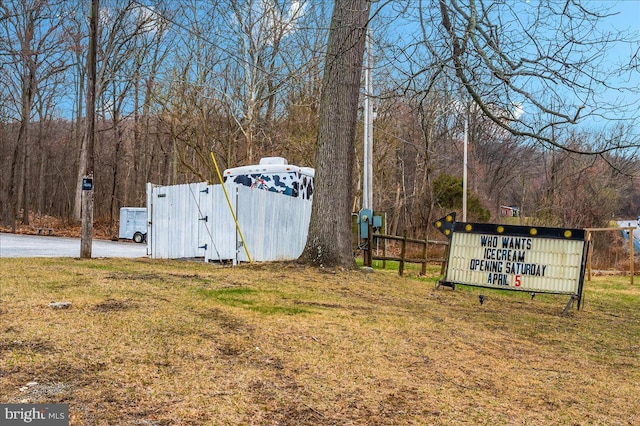 view of yard featuring a view of trees, fence, and a gate