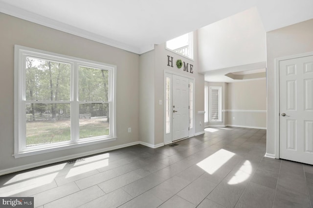 foyer entrance with baseboards and dark tile patterned flooring
