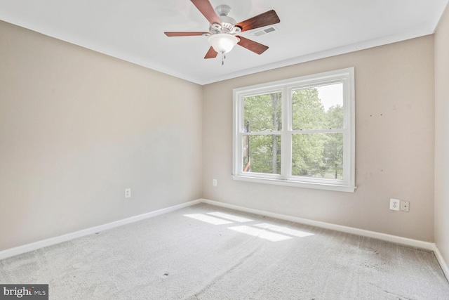 carpeted spare room featuring baseboards, a ceiling fan, and visible vents