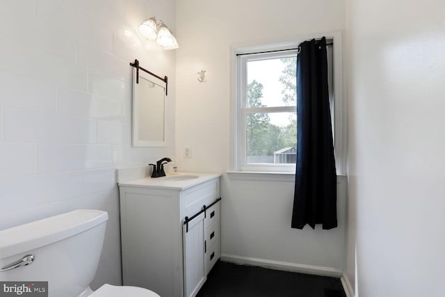 bathroom with toilet, plenty of natural light, and vanity