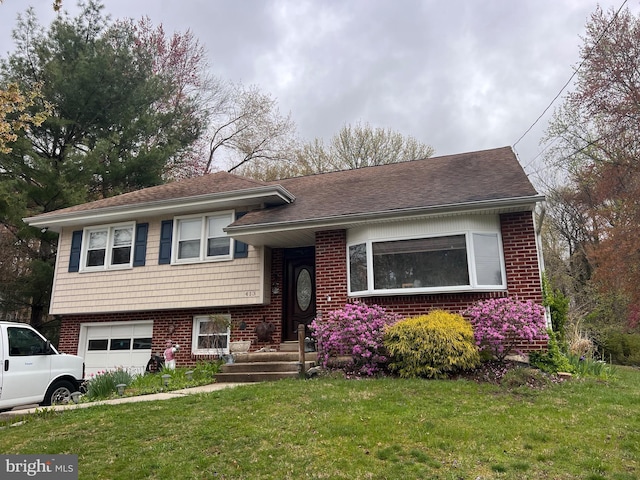 split level home featuring brick siding, a front lawn, and an attached garage