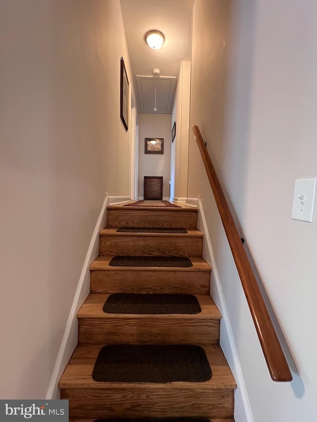 staircase with baseboards and attic access