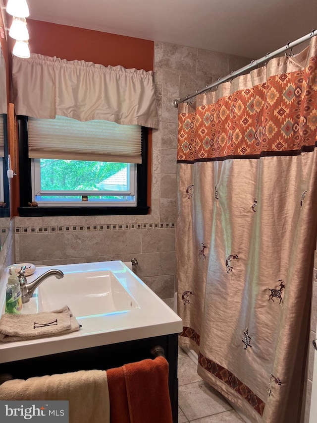 full bathroom with tile patterned floors, tile walls, curtained shower, and vanity