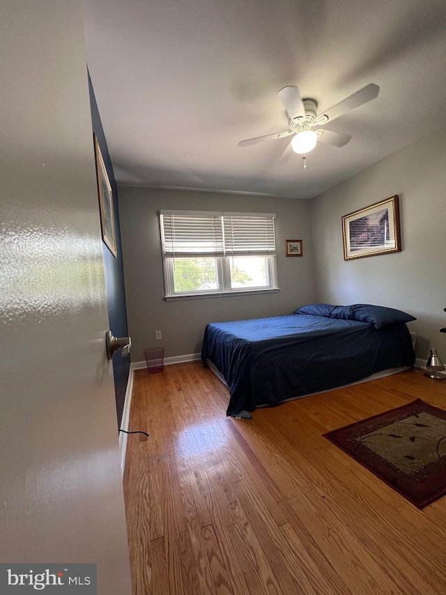 bedroom with baseboards, ceiling fan, and wood finished floors