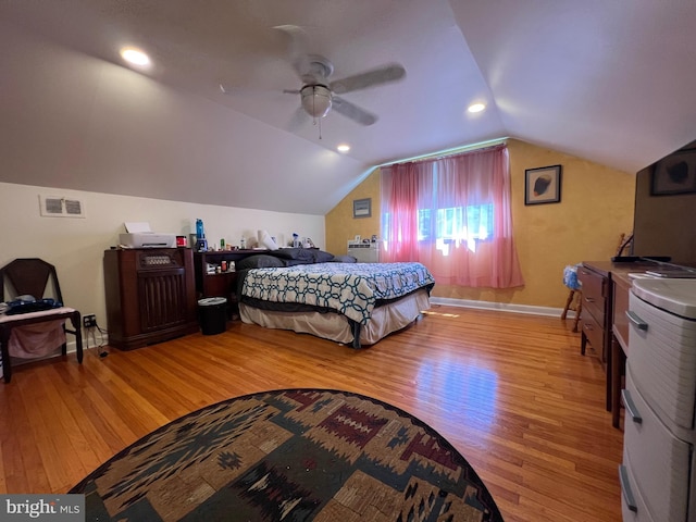 bedroom featuring visible vents, light wood finished floors, baseboards, and vaulted ceiling
