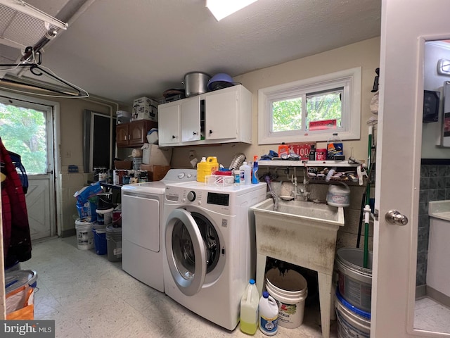 laundry area featuring washer and dryer, light floors, and cabinet space
