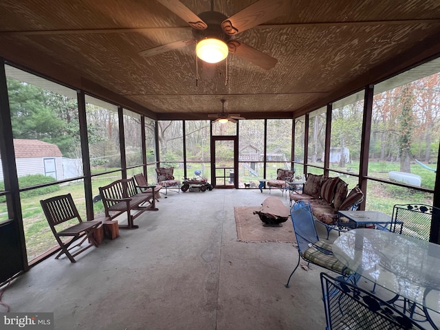 unfurnished sunroom featuring outdoor dining area, a ceiling fan, and an outdoor hangout area