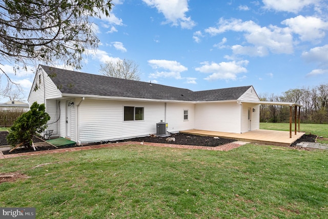 rear view of house featuring a yard, central AC, and a shingled roof