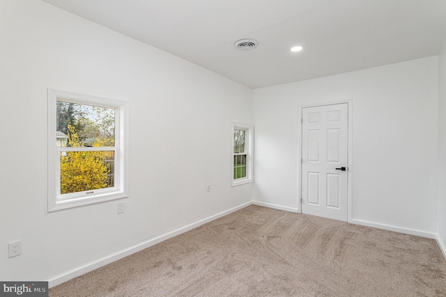empty room featuring visible vents, baseboards, recessed lighting, and carpet floors