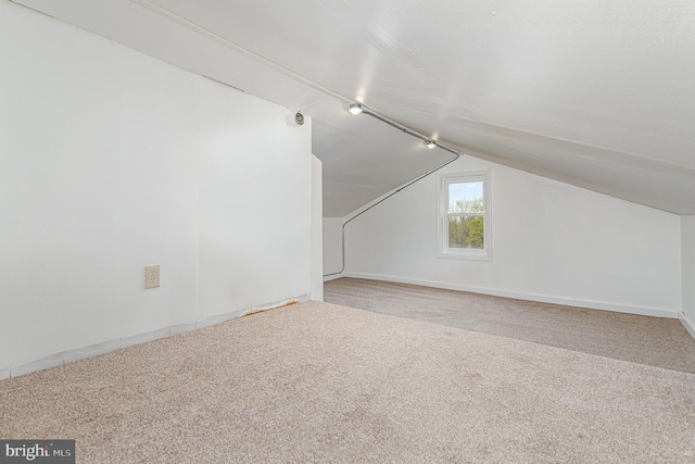 additional living space featuring carpet, baseboards, and lofted ceiling