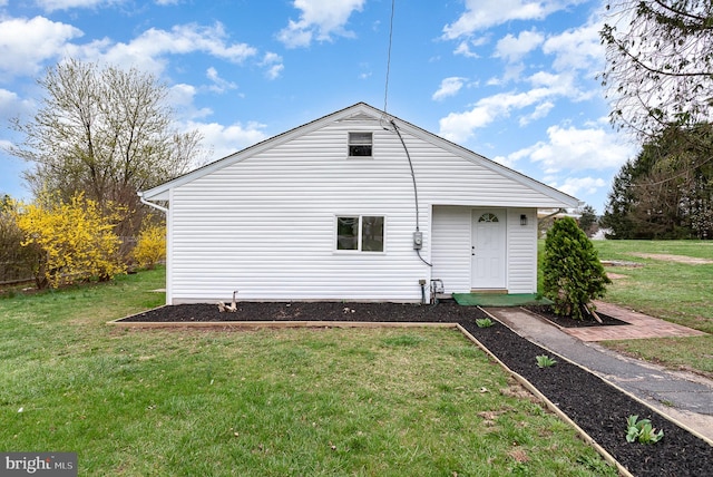rear view of house featuring a lawn